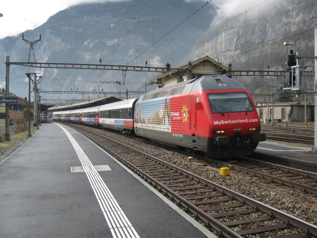Re 460 036 mit dem Extrazug Snow Train, Brig-Geneve-Aeroport, bei Durchfahrt in St-Maurice, 19.03.2011. Der Zug besteht aus zwei Salon- und drei Erstklasswagen. 