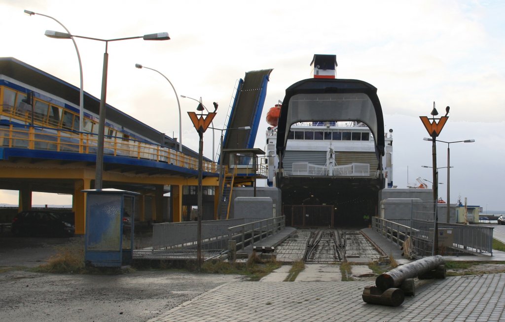 Sassnitz Hafen, 27.12.2012. Zwei nutzlose Rangiersignale / Wartezeichen erinnern an den Eisenbahn-Fhrverkehr. (2000 eingestellt) Sie wurden wohl links aus der blauen Telefonzelle heraus bedient. Das Fhrschiff  Sassnitz  im Hintergrund.