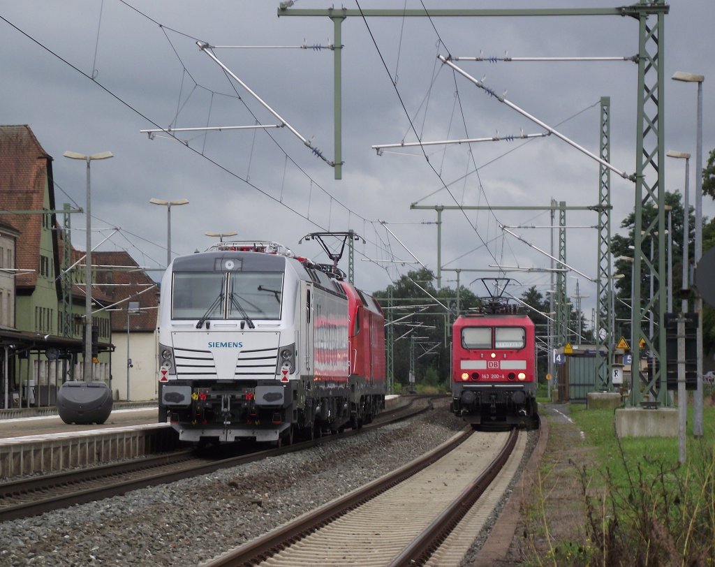 Whrend auf Gleis 4 die 143 200-4 mit einer RB aus Hochstadt-Marktzeuln pausiert berfhrt 182 017-4 am 7. August 2011 die Siemens Vectron durch Kronach.