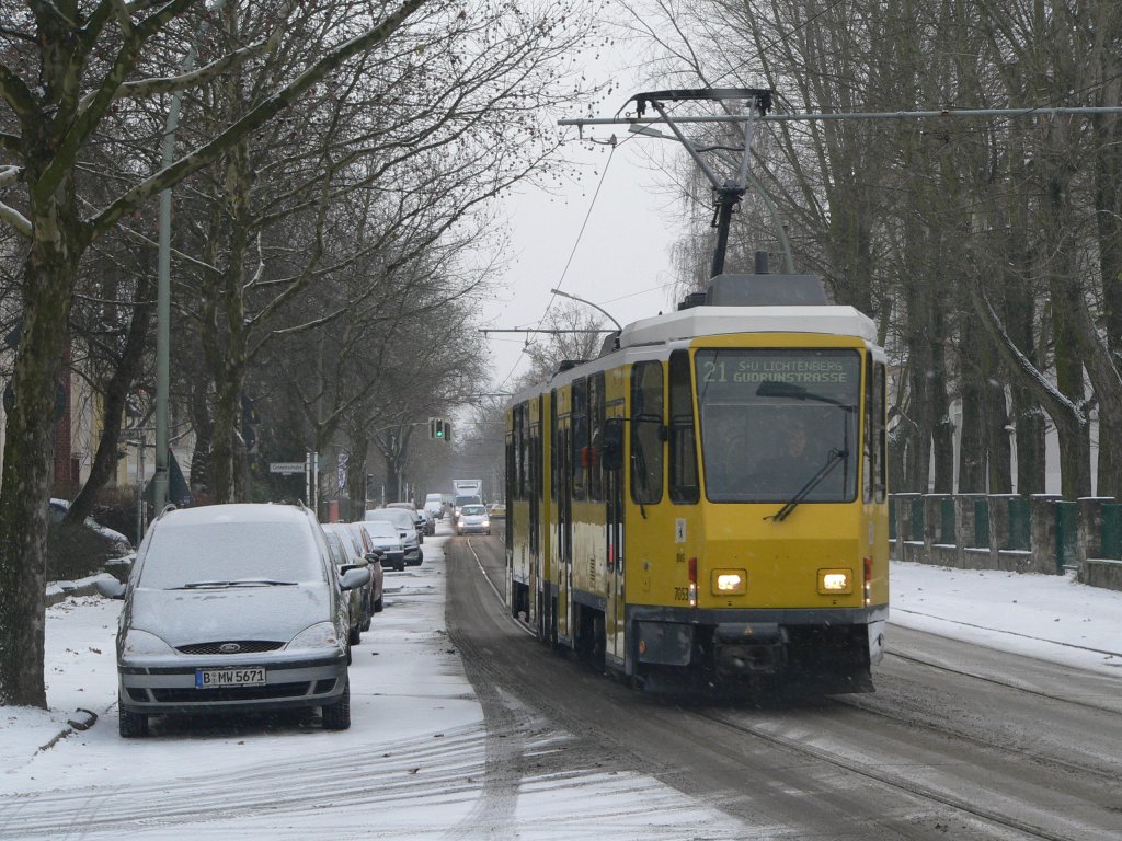 Zuverlssig - auf die Minute pnktlich passiert diese Tram der Linie 21 - Fahrzeug 7053 der BVG - die ehemalige Haltestelle Blockdammweg/Ehrlichstrae. 18.12.2009