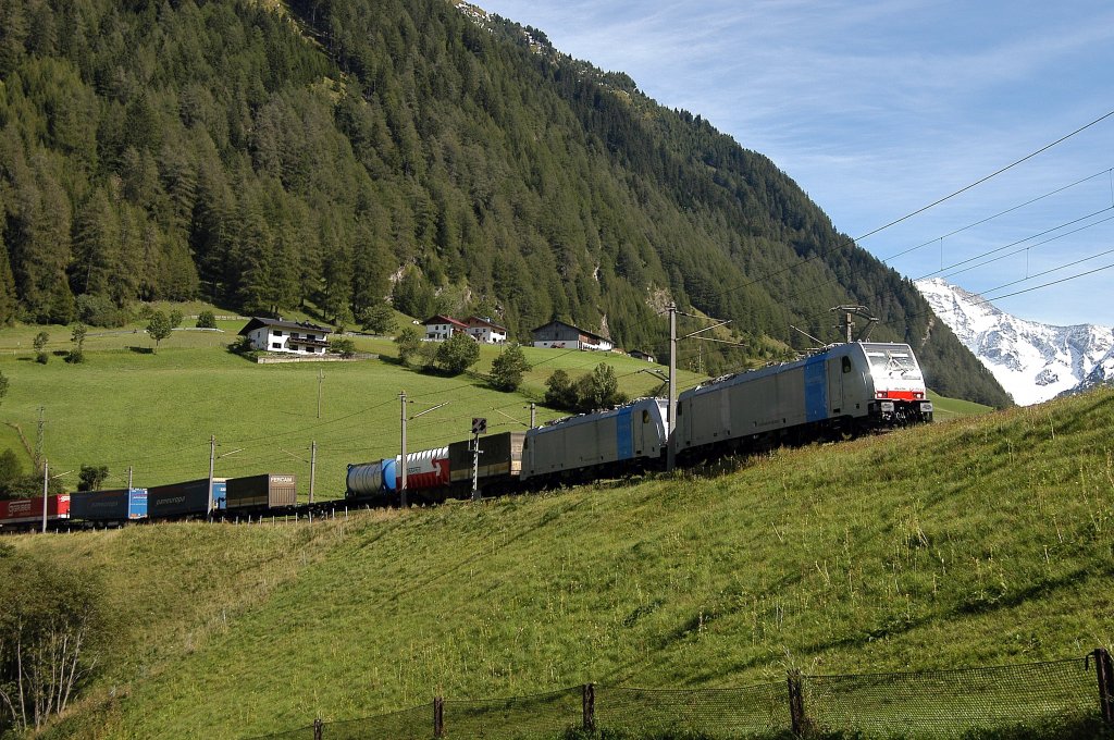 zwei Railpool 186er  ziehen einen KLV-Zug durch die St. Jodoker Kurve in Richtung Brenner. Im Hintergrund die mit Neuschnee bedeckten Berge am Ende des Valser Tals, 02.09.10  