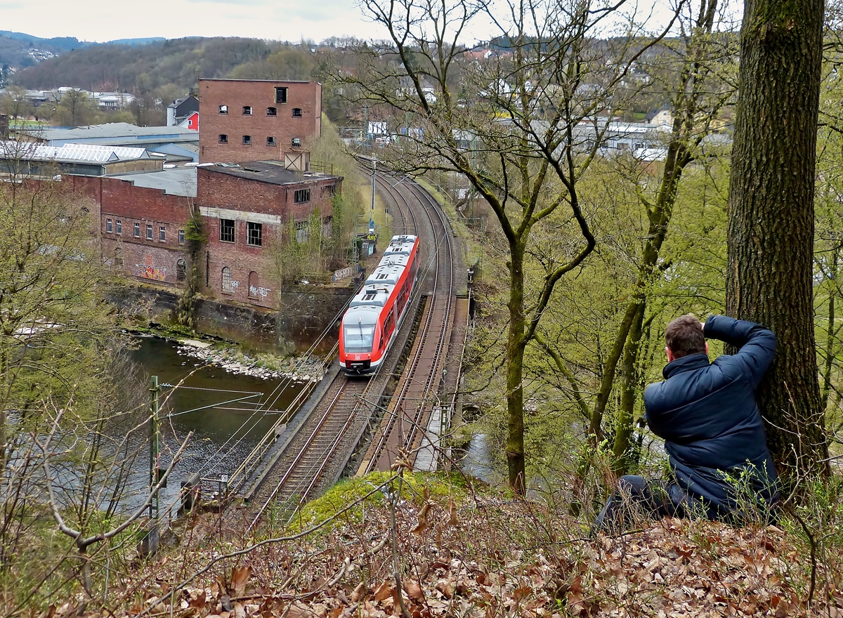 . Der Fotograf und sein Sujet - Hoch oben ber dem Mhlburg Tunnel in Scheuerfeld/Sieg hat Armin Position bezogen, um den Alstom Coradia LINT 41 der DreiLnderBahn abzulichten.  

Der Zug hat soeben den Bahnhof in Scheuerfeld verlassen und fhrt als RB 95 Dillenburg - Siegen - Au/Sieg dem Mhlburg Tunnel entgegen. 22.03.2014 (Jeanny)