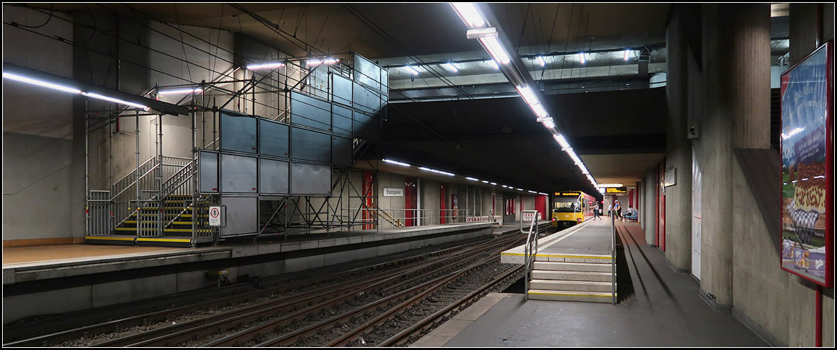 . Die Zeit der Station Staatsgalerie ist abgelaufen -

Nur noch ein paar Jahre lang werden die Stadtbahnen an dieser U-Station halten, dann wird unter freiem Himmel ein und ausgestiegen werden können. Der früherer Treppenzugang zum gegenüberliegenden Bahnsteig liegt im Bereich der Baustelle und wurde deshalb durch eine provisorische Treppe ersetzt. Auf dem mittleren Gleis der dreigleisigen Station wenden derzeit die Züge der Linie U4, da die Strecke in Richtung Charlottenplatz zur Zeit langfristig wegen der Bauarbeiten gesperrt ist.

Die Station macht schon jetzt einen sehr heruntergekommen Eindruck, eine Treppe zum Bahnsteig wurde als Toilette missbraucht.

Stuttgart, 29.07.2017 (M)