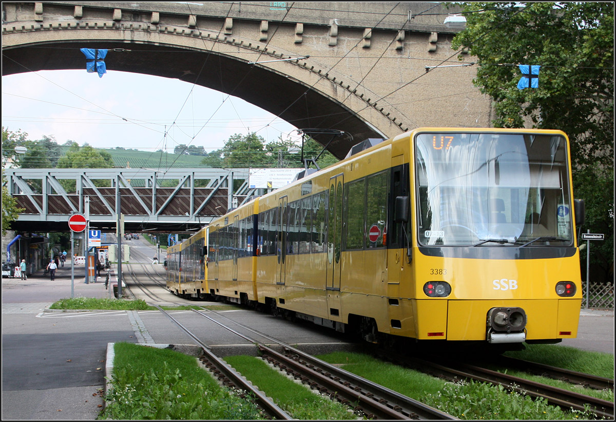 . Spaziergang entlang der Nordbahnhof- und Friedhofstraße, Teil I -

Vom 23. August bis 14 September wurden die Bahnen der Linie U6 und U7 über die Nordbahnhofstraße und die Friedhofstraße umgeleitet. Da dieser Streckenabschnitt sehr fotogen ist und auch durch die Neigungswechsel und Bogen in diesem Abschnitt gerade bei längeren Züge spannend sind nutzt ich die Gelelgenheit, dies mit der Kamera festzuhalten. Die Linie U12 wurde in diesem Zeitraum mit der Linie U15-Nord nach Stammheim verknüpft, so waren nur die Züge der U6 und U7 unterwegs. 

14:48: Nachschuss auf eine Bahn der Linie U7, deren Zugzielanzeige nicht richtig funktionierte. Vorne war ohne Linienangabe Ostfildern angezeigt obwohl Mönchfeld korrekt gewesen wäre, während hinten nur U7 zu sehen war.
Der Zug fährt soeben in die Haltestelle Nordbahnhof ein. Darüber die Bogenbrücke der Gäubahn.

08.09.2014 (M)