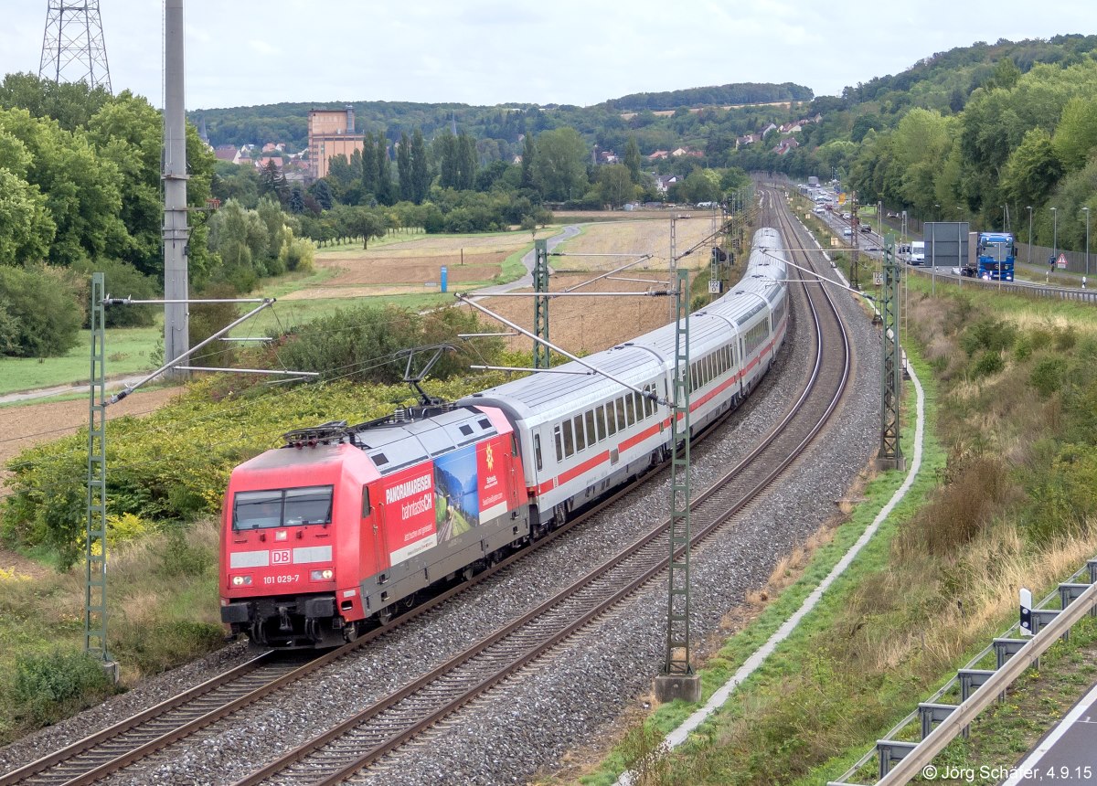 101 029 erreichte mit dem IC Oberstdorf - Hamburg am 4.9.15 den km 122 zwischen Ochsenfurt und Goßmannsdorf. Hinten links das große Baywa-Gebäude in Ochsenfurt, vor dem die Gleise der Hafenbahn liegen, siehe Bild 990837. 