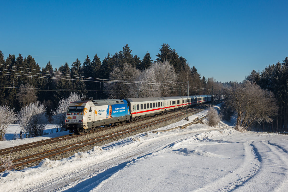 101 055  Schauinsland Reisen  zieht den IC 2082  Königsee  bei Grabenstätt in Richtung München, aufgenommen am 29. Januar 2017.