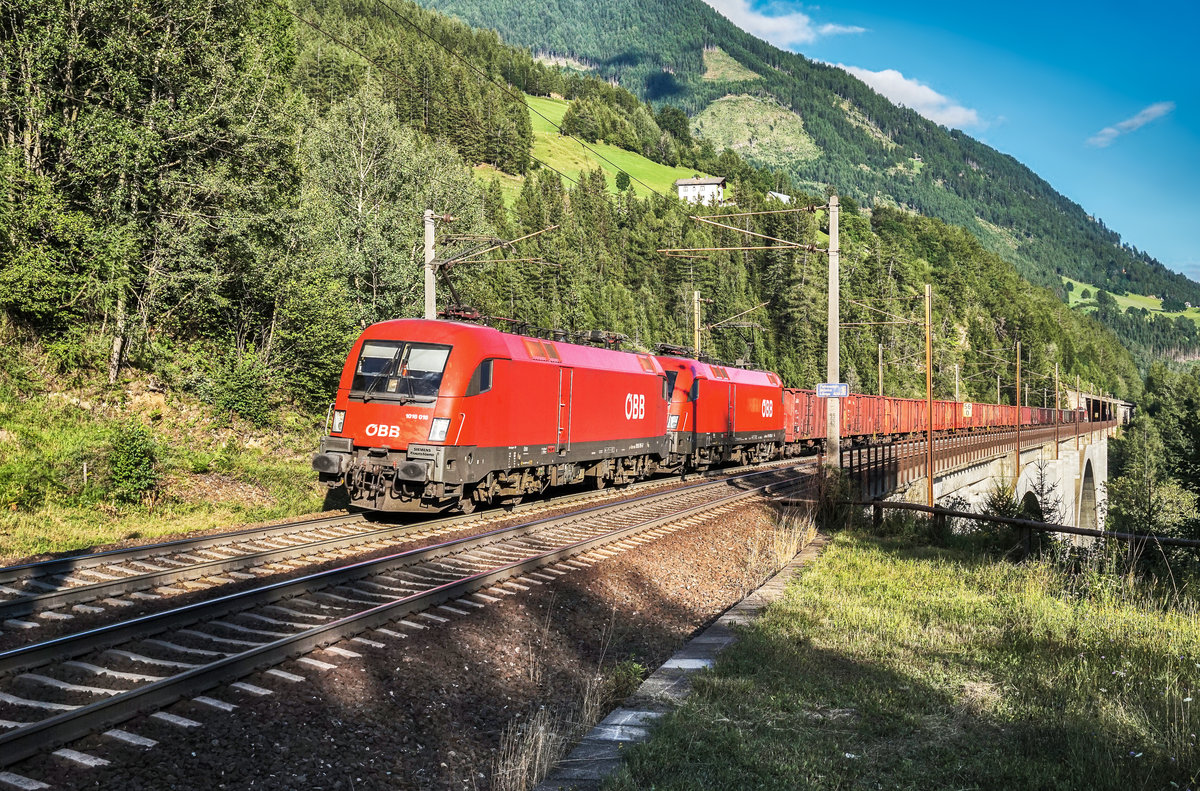 1016 016-8 und 1116 085-2 überqueren mit einem Güterzug die Falkenstein-Brücke kurz vor der Haltestelle Oberfalkenstein.
Schublok war 1144 205-2.
Aufgenommen am 7.8.2017.
