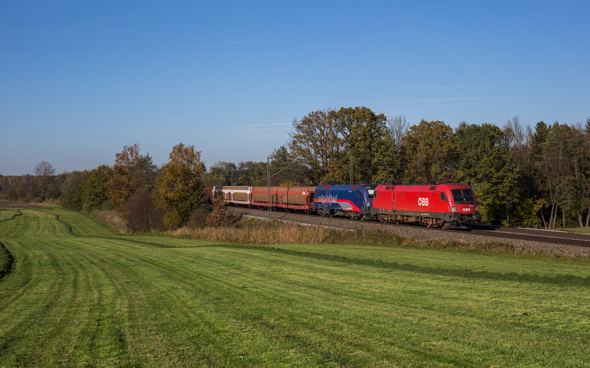 1016 038 und 1116 195  Nightjet  fahren mit einem gemischten Güterzug bei Hilperting in Richtung Salzburg, aufgenommen am 19. Oktober 2017.