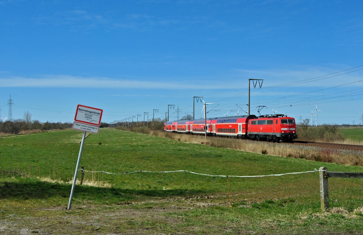 111 084 fuhr am 04.04.2015 mit einem RE von Emden nach Münster, hier bei Petkum.