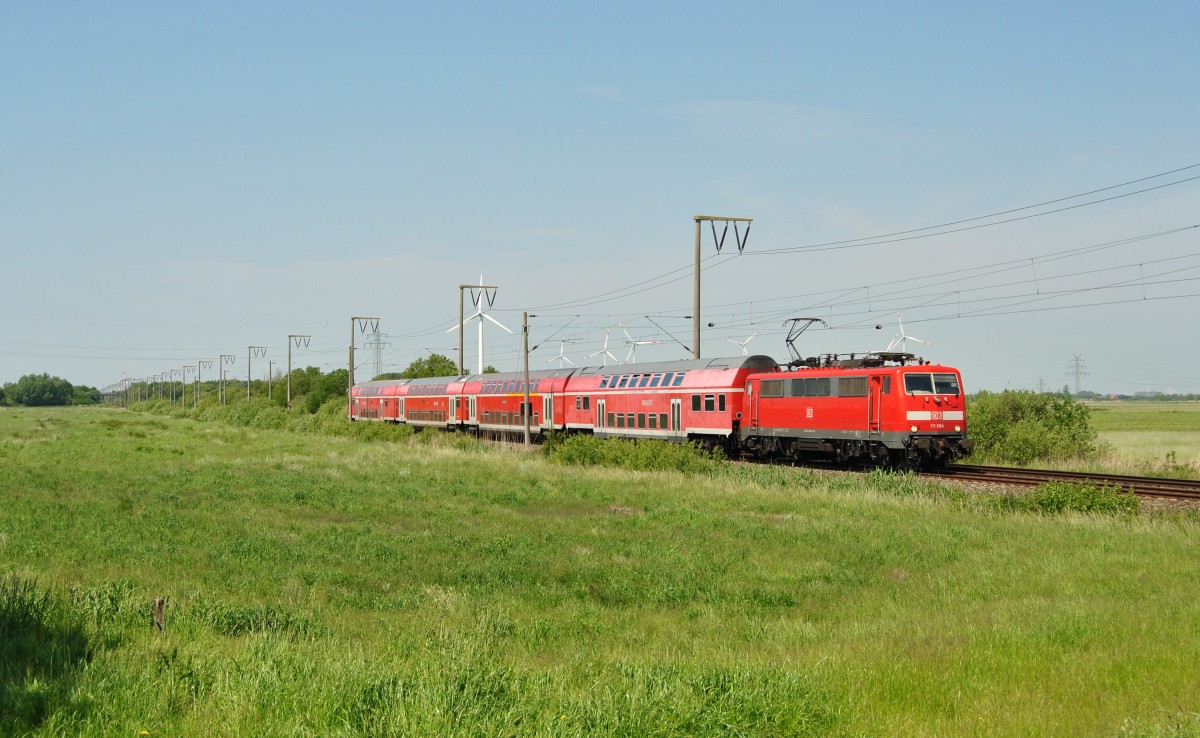 111 084 fuhr am 05.06.2015 mit einem RE von Emden nach Münster, hier bei Petkum.