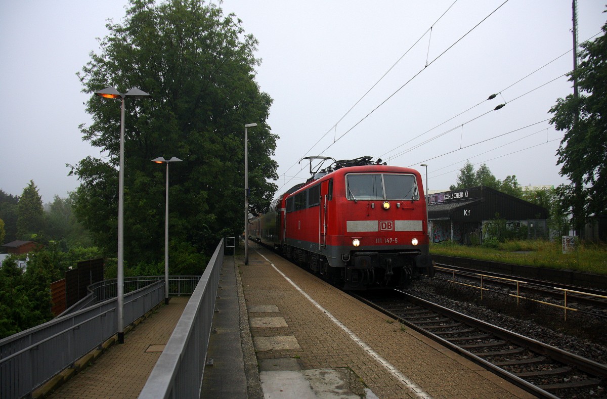 111 147-5 DB kommt die Kohlscheider-Rampe hoch aus Richtung Neuss,Herzogenrath mit einem RE4 aus Dortmund-Hbf-Aachen-Hbf und fährt durch Kohlscheid in Richtung Richterich,Laurensberg,Aachen-West. 
Bei Regenwetter am Morgen vom 10.7.2014.