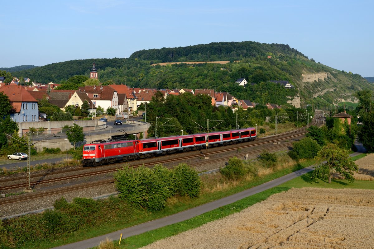 111 225 erreicht am Abend des 18. Juli 2014 mit ihrem aus den sogenannten PUMA-Wagen gebildeten RE 4624 den Bahnhof Retzbach-Zellingen. Aufgrund der Kürze bietet sich der Zug zur Umsetzung im Modell gerade zu an.