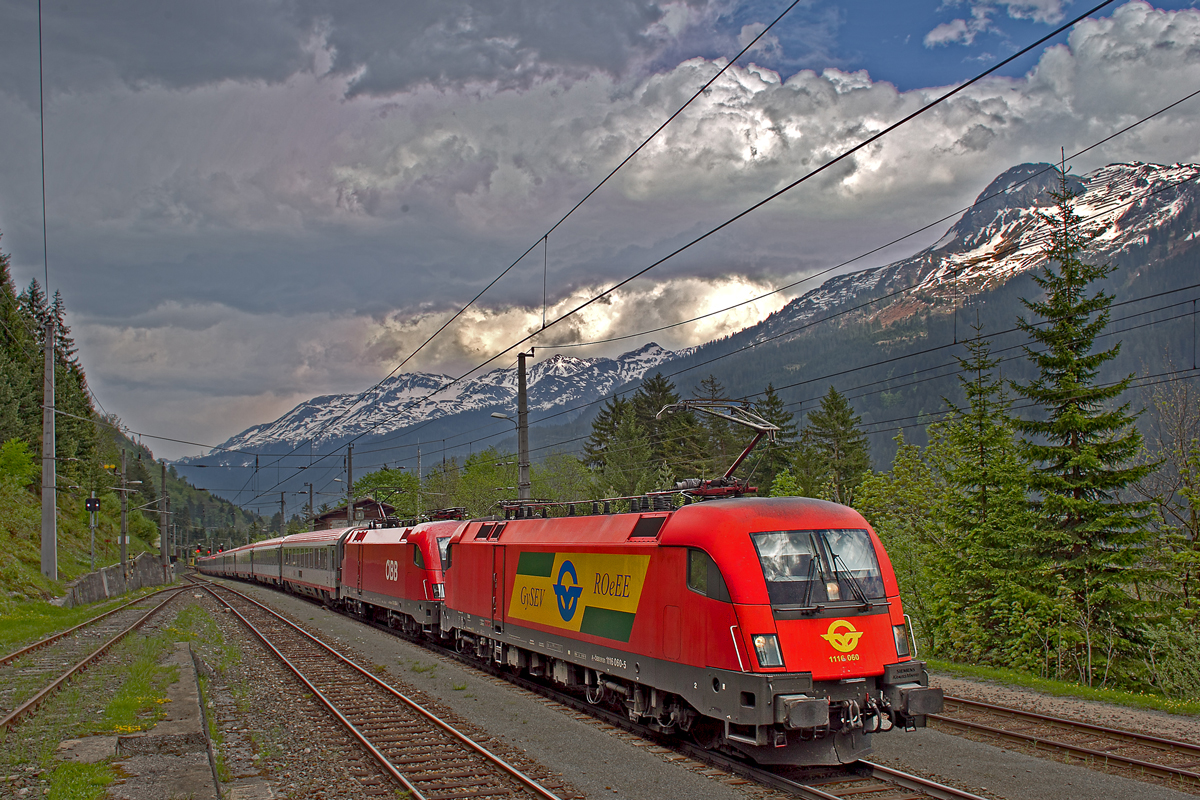 1116 060 mit einer Schwesterlok fährt bei einem aufziehenden Gewitter mit dem EC 164 von Graz Hbf nach Zürich HB talwärts bei Wald a/A vorüber.Bild vom 13.5.2015