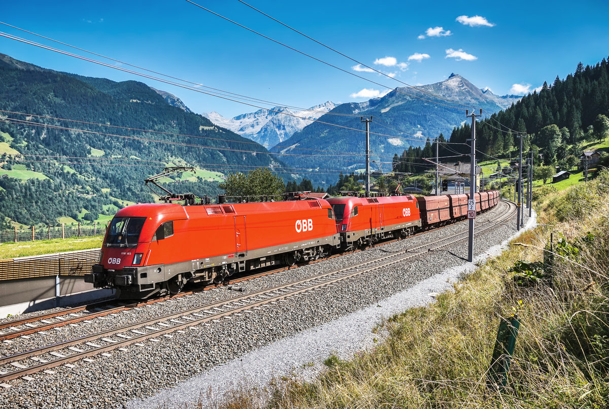 1116 183-5 und 1016 047-3 durchfahren mit einem Erzzug in Richtung Schwarzach-St. Veit, den ehemaligen Bahnhof Angertal.
Aufgenommen am 30.8.2017.