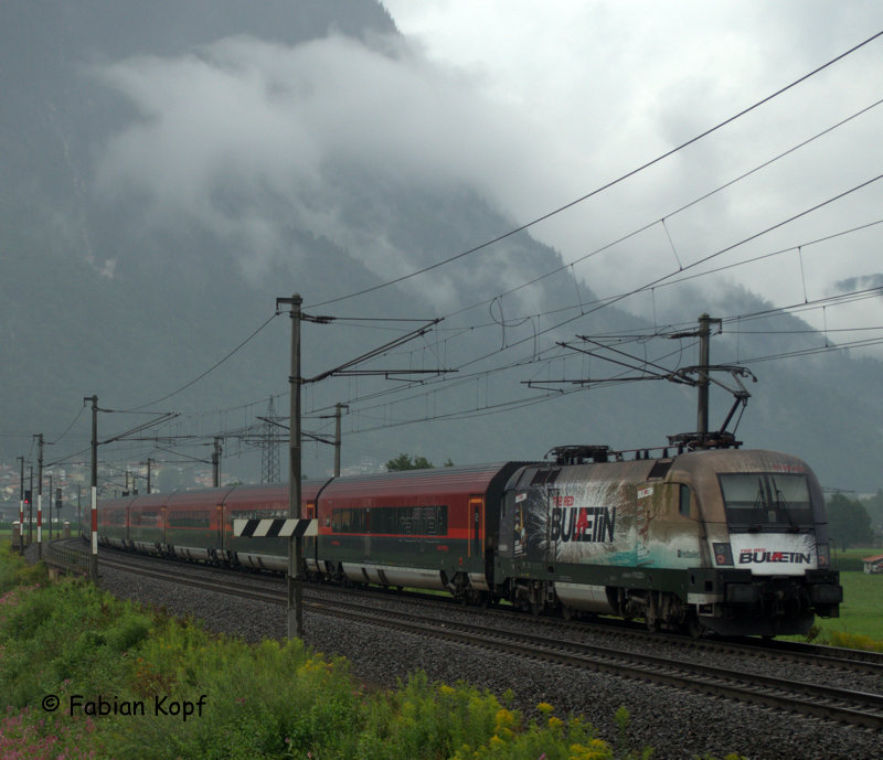 1116 222  The Red Bulletin  an einem Railjet nach Wien Westbahnhof bei Langkampfen am 31.07.2014 bei schlechtem Wetter.