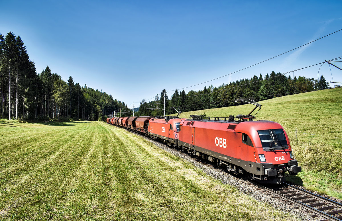 1116 282-5 und 1216 147-9 fahren mit einem Güterzug, auf der Fahrt in Richtung Jesenice, bei Schlatten, nahe Rosenbach vorüber.
Aufgenommen am 28.8.2018.