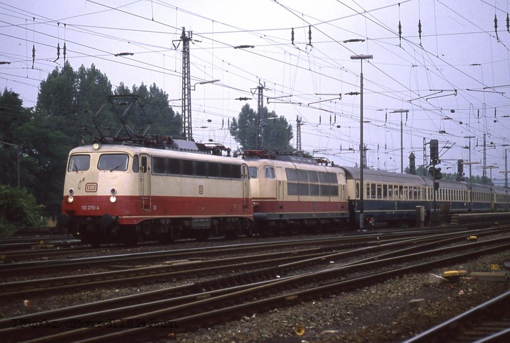 112270 hat am 15.9.1988, hier bei der Ausfahrt um 9.50 Uhr in Osnabrück HBF, nicht nur den D 2737 nach Westerland am Haken. Hinter der Lok läuft abgebügelt auch 103124 mit.