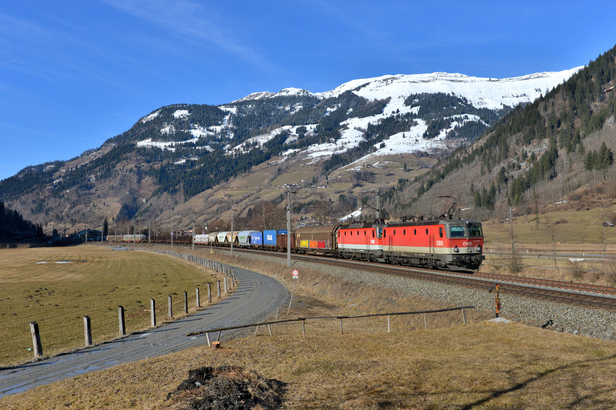 1144 010 + 1144 114 mit einem Güterzug am 07.03.2015 bei Dorfgastein.  