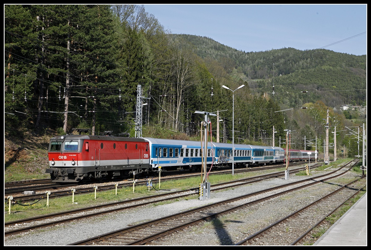 1144 053 mit EC159 fährt am 19.04.2018 durch den Bahnhof Payerbach - Reichenau.
