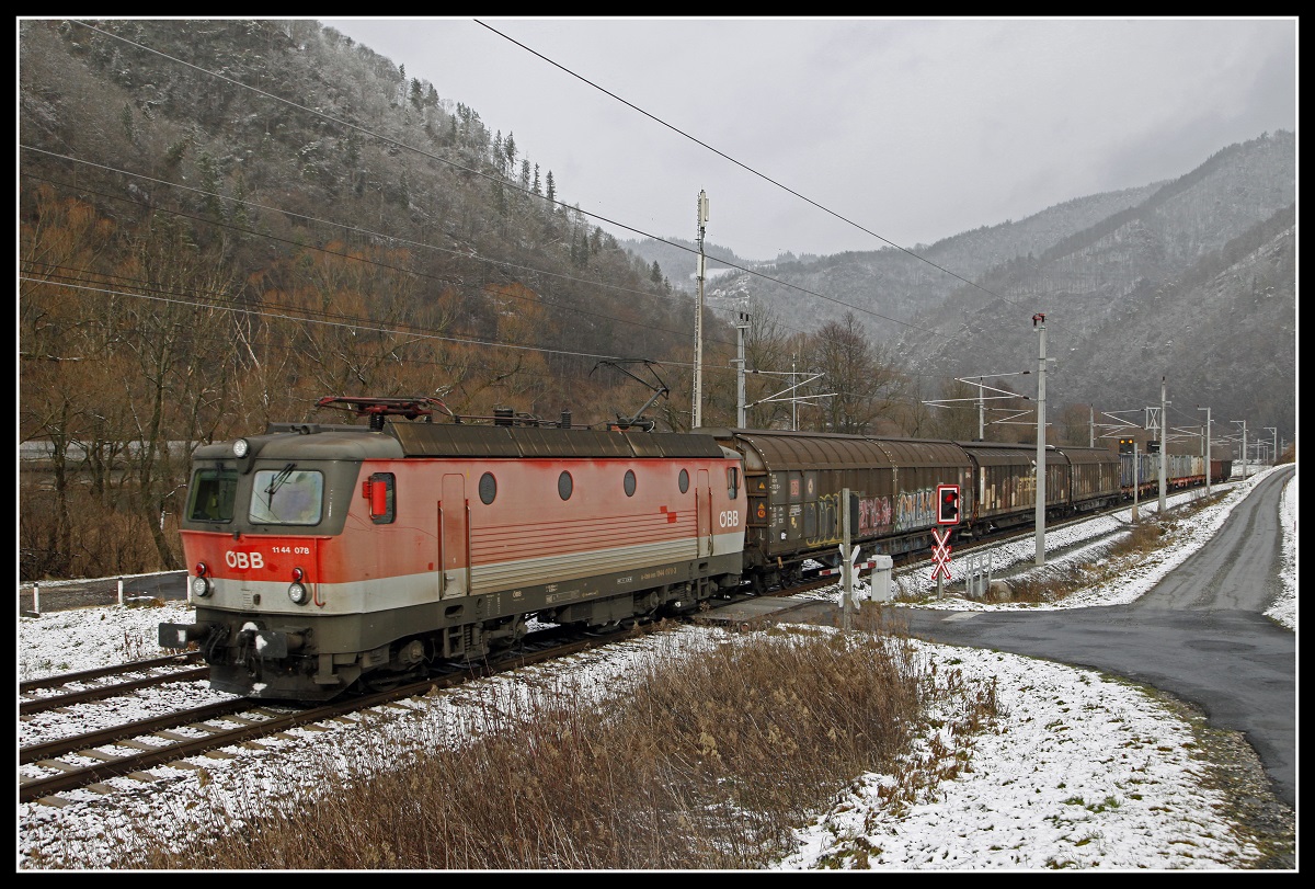 1144 078 mit Güterzug zwischen Bruck an der Mur und Pernegg am 11.12.2018.