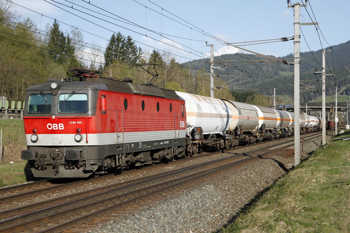 1144 100 mit einem Güterzug hat am 21.04.2015 soeben die aufgelassene Haltestelle Oberaich durchfahren.