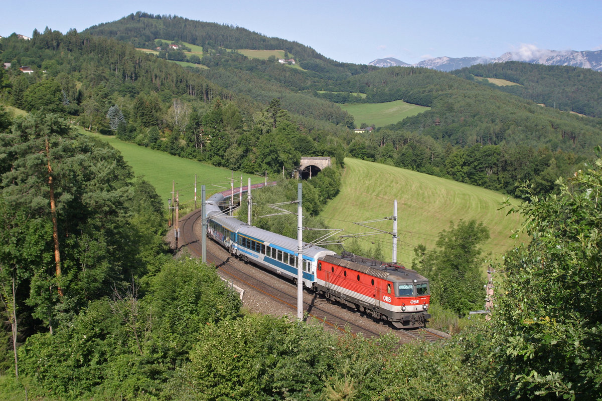 1144.211 bringt am 23.7.16 den EC-151 vor Kreuzberg und Rax beim Steinbauer-Tunnel am Eichberg über den Semmering.