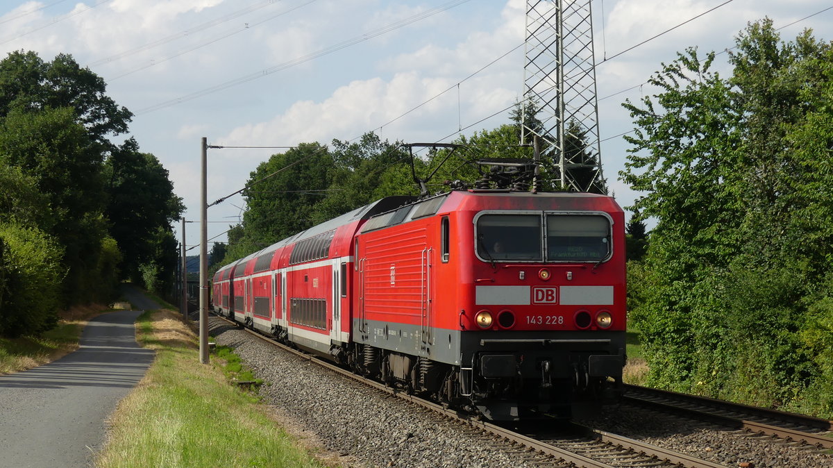143 228 zieht einen RE20 nach Frankfurt an einer Fotostelle südlich von Wörsdorf vorbei. Aufgenommen 6.7.2018 17:22