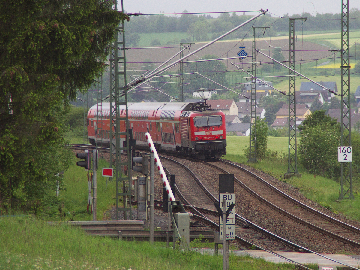 143 893-6 schiebt ihren RE aus Dresden der Endstation Hof entgegen. Kurz vor dem Zielbahnhof hat der Zug den BÜ Km 160,1 an der Bundesstraße 2 überquert. Bahnstrecke 6362 Leipzig - Hof am 24.05.2016