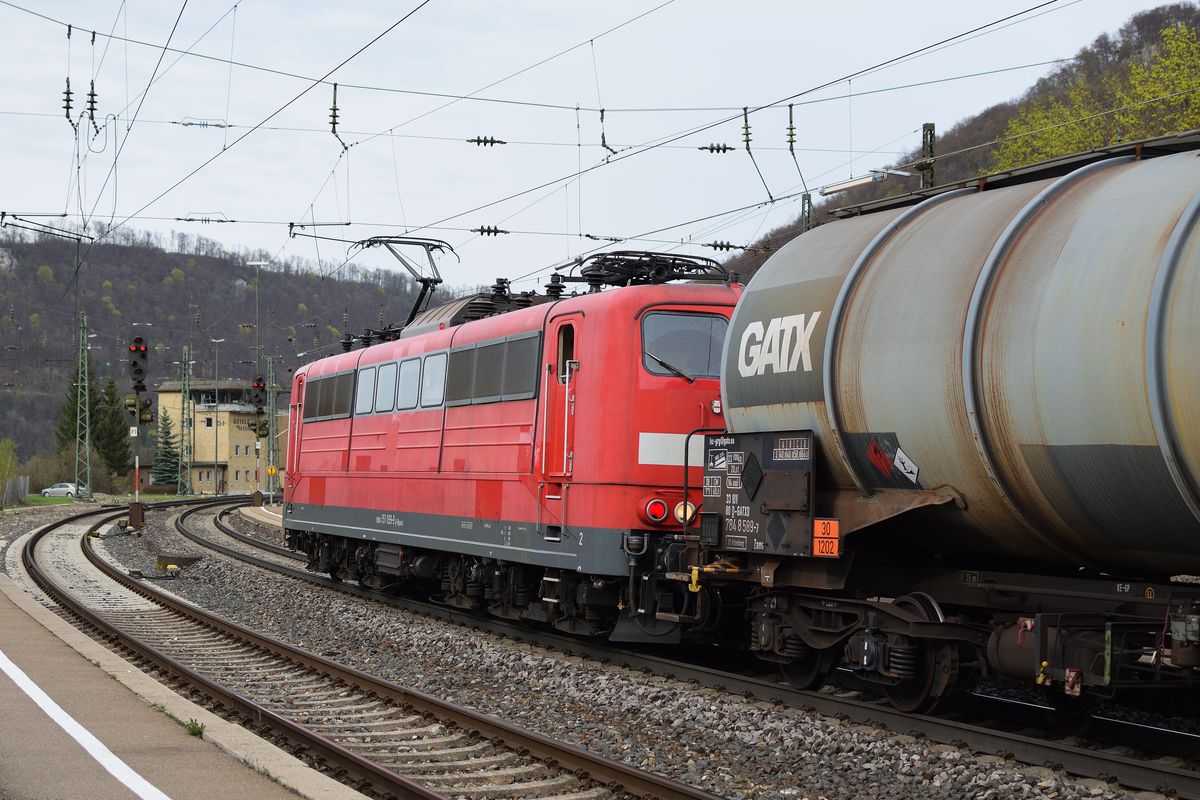 151 099 schiebt am 15. April 2018 einen von 185 587 gezogenen Kesselwagenganzzug durch den Geislinger Bahnhof der gleichnamigen Steige entgegen.