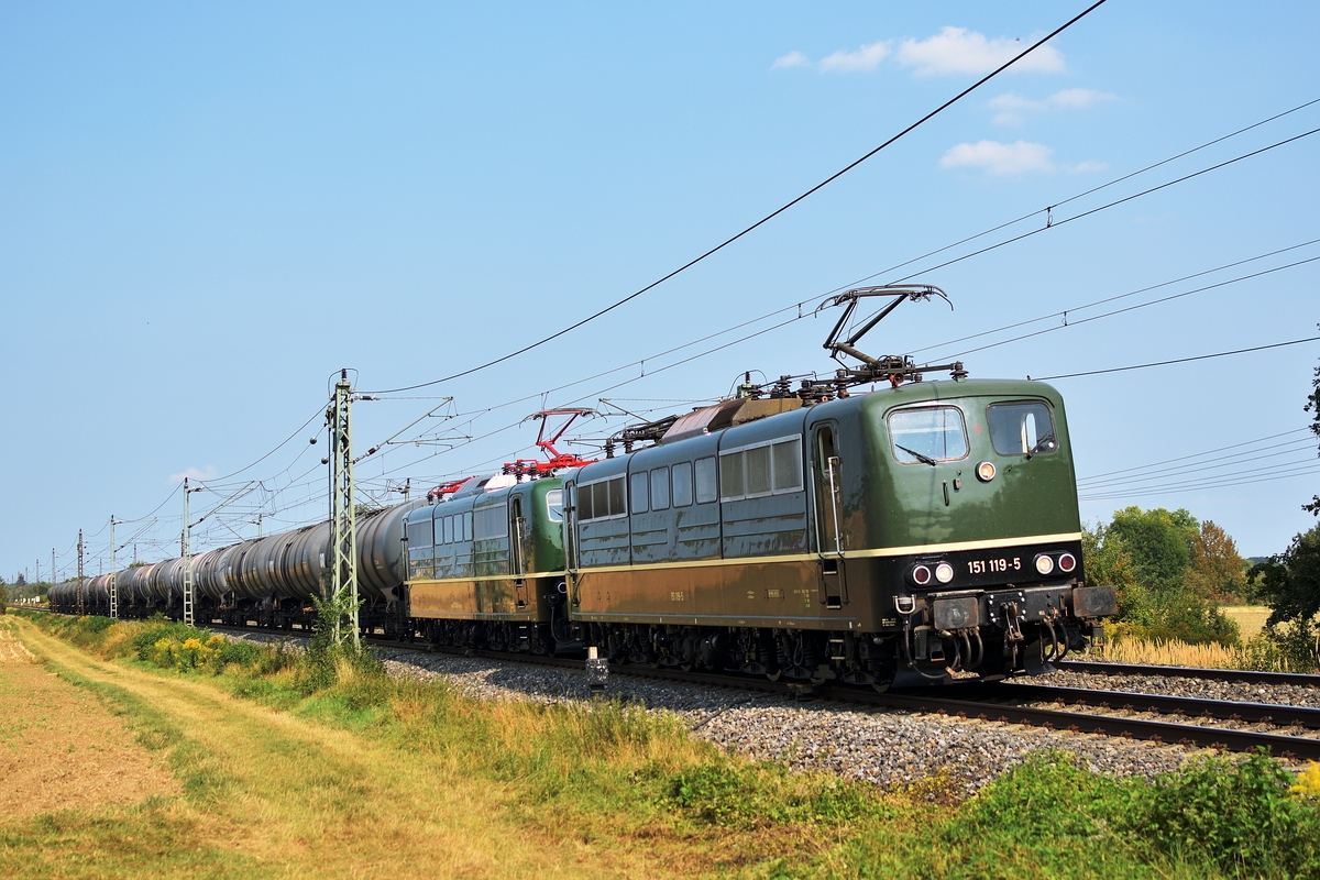 151 119 und 1151 038 der BayernBahn bespannen am 28. August 2018 einen Kesselwagenganzzug. Hier ist der Zug bei Pfuhl, kurz von Neu-Ulm, auf der Fahrt Richtung Ulm.