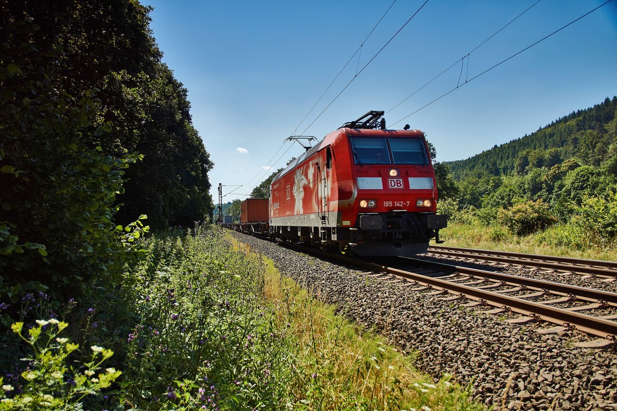 185 142-7 ist am 20.07.16 mit einen Containerzug bei Burghaun in Richtung Bebra unterwegs.Der Sicherheitsabstand zum Gleis wurde gewart.