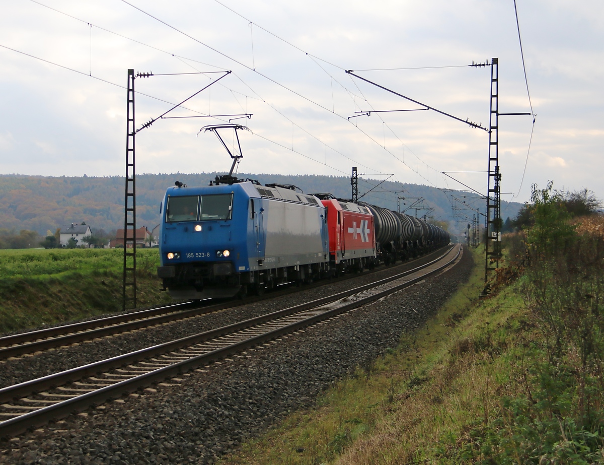 185 523-8 mit der Wagenlok 185 631-9 und einem Kesselwagenzug in Fahrtrichtung Norden. Aufgenommen zwischen Mecklar und Ludwigsau-Friedlos am 26.10.2014.