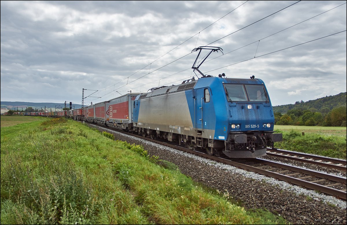 185 529-5 ist am 07.09.2017 mit einen Aufliegerzug bei Retzbach in Richtung Gemünden/M. unterwegs.