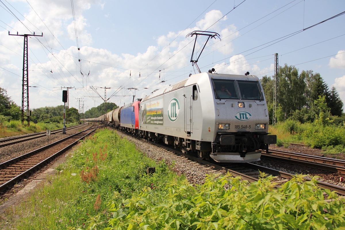 185 548-5 in Doppeltraktion mit einer weiteren 185 und Getreidezug bei der Durchfahrt von Leipzig-Thekla. Aufgenommen am 12.07.2013.