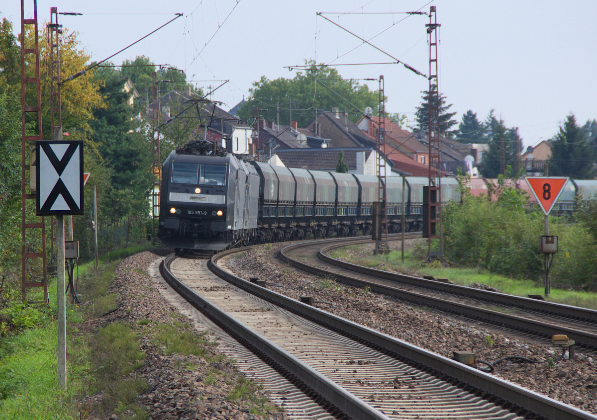 185 551 und eine Schwesterlok kommen vom Kraftwerk Fenne und fahren zurück ins Ruhrgebiet um Kohlennachschub zu holen. Gleich donnert der Zug mit Touax Wagen über den Bahnübergang in Saarlouis Roden. Bahnstrecke 3230 Saarbrücken - Karthaus am 28.09.2013