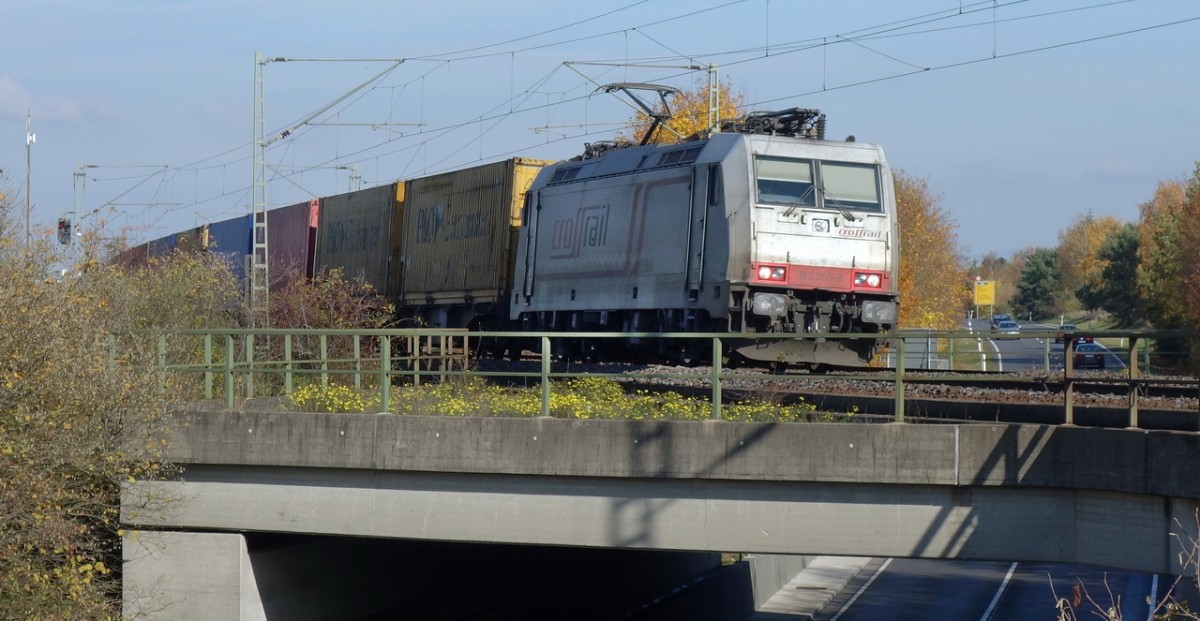 185-580-8 der Crossrail überquert am 8.11.2015 auf der Rheinbahn mit einem Containerzug die B36 bei Neulußheim Richtung Süden