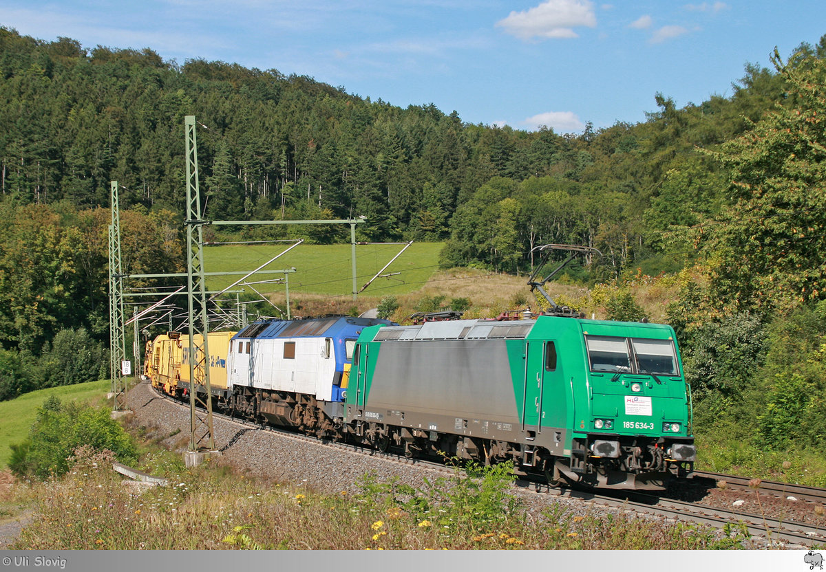 185 634-3 der Holzlogistik und Güterbahn und eine Mak DE 2700 mit einem Bauzug am Haken kurz nach der Durchfahrt des Ramholztunnels am 17. August 2016.