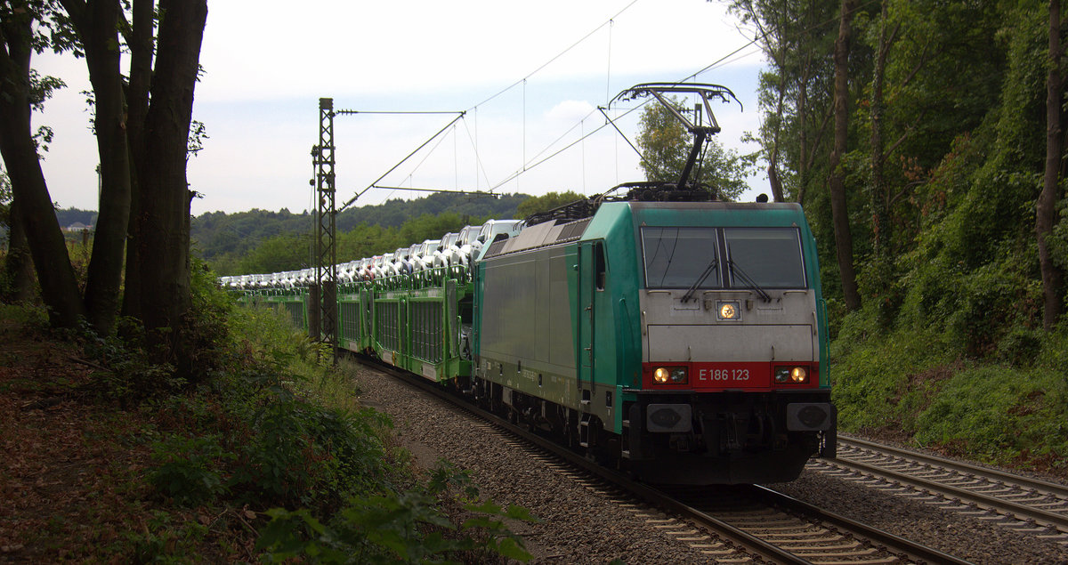 186 123 von Railtraxx kommt die Gemmenicher-Rampe herunter nach Aachen-West mit einem Volvo-Autozug aus Belgien nach Sankt-Valentin(A). 
Aufgenommen an der Montzenroute am Gemmenicher-Weg. 
Bei Wolken am Nachmittag vom 1.8.2018.