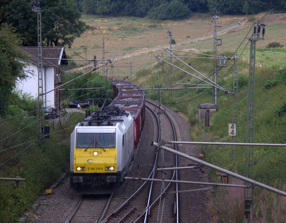 186 319-0 der Euro-Cargo-Rail l kommt aus Richtung Aachen-West und fährt die Gemmenicher-Rampe hoch mit einem Schrottzug aus Köln-Kalk(D) nach Genk-Goederen(B)  und am Ende fährt 185 235-9 DB als Schubhilfe bis zum Gemmenicher-Tunnel. 
Aufgenommen in Reinartzkehl an der Montzenroute. 
Am Abend vom 8.8.2018.