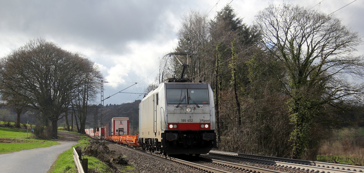 186 452-9 von Lineas/Railpool kommt die Gemmenicher-Rampe herunter nach Aachen-West mit einem Containerzug aus Belgien nach Aachen-West(D) und fährt in Richtung Aachen-West. 
Aufgenommen an der Montzenroute am Gemmenicher-Weg. 
Bei Sonne und Regenwolken am Mittag vom 5.3.2019.