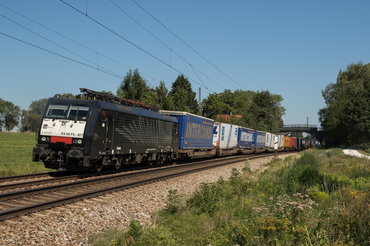 189 927 mit einem Aufliegerzug am 29. August 2015 bei Übersee.