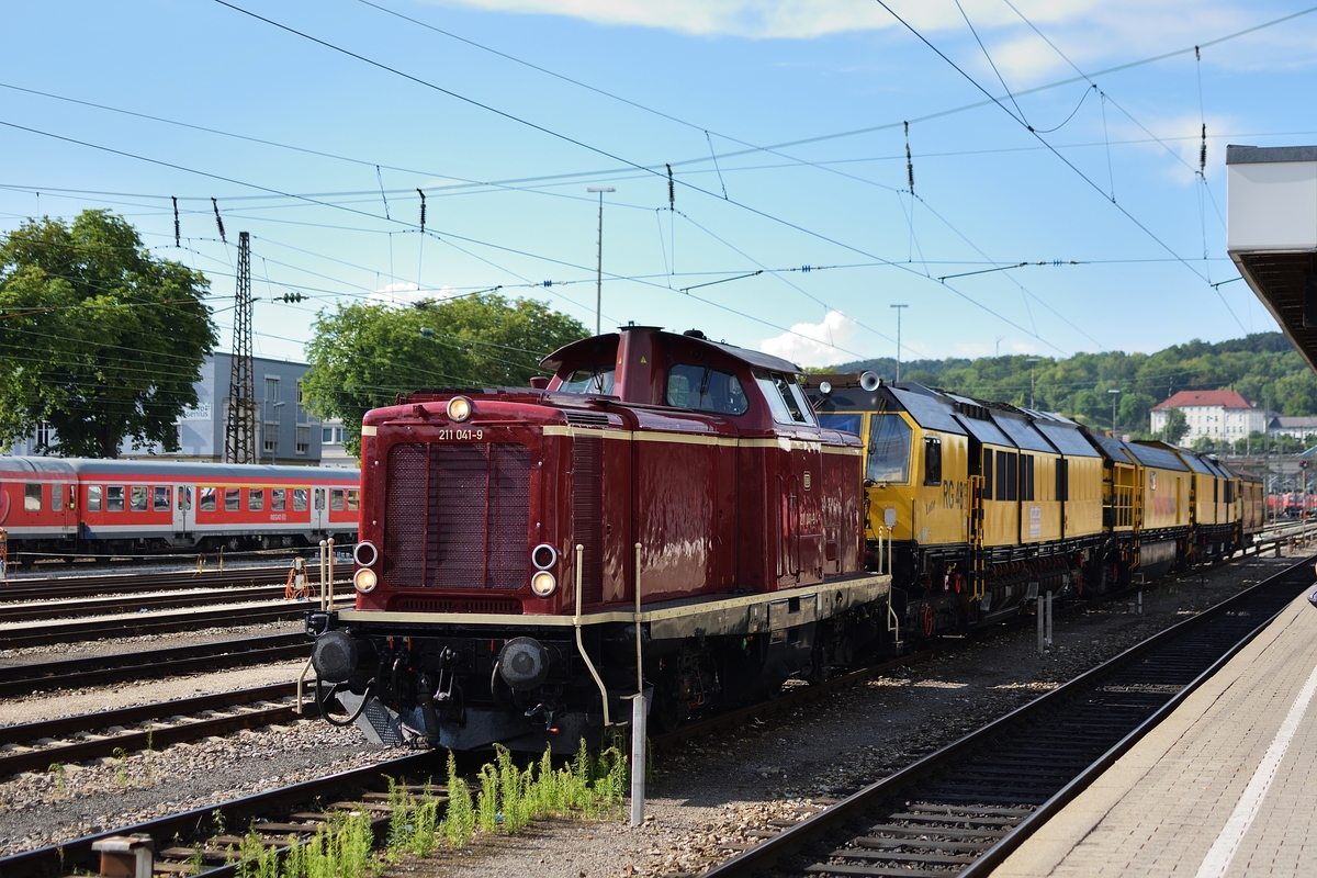 211 041 der NeSa steht am Abend des 6. Juli 2018 mit der Schienenschleifmaschine  Lotte  in Ulm.