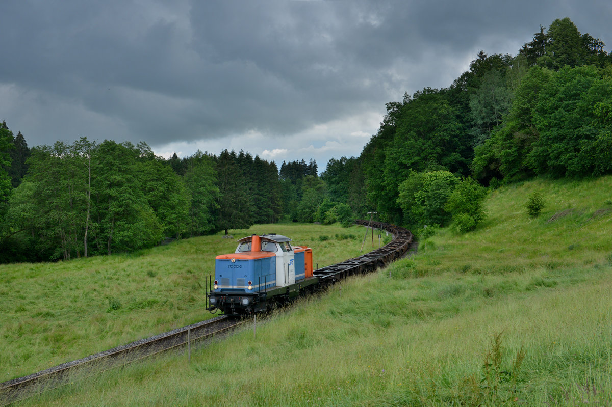 212 242 mit einer Leerwagenüberführung am 13.06.2016 bei Röhrnbach. 