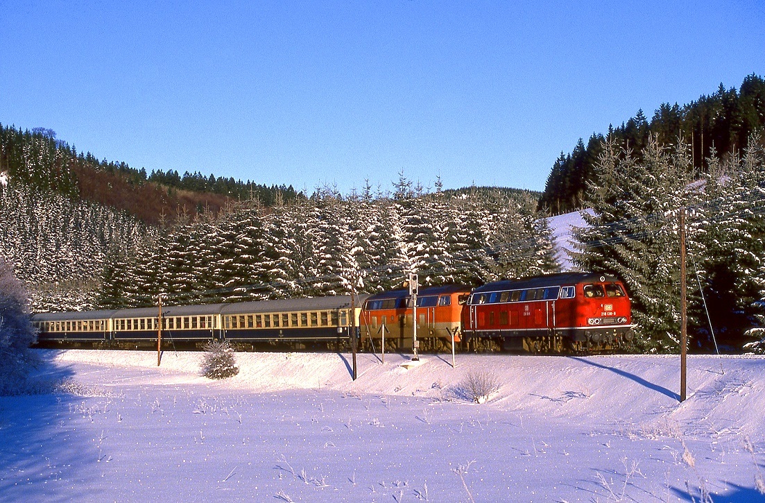 218 138 und 218 140 bringen einen Zug mit Wintersportlern nach Winterberg. Aufnahme bei Siedlinghausen, 01.02.1987.