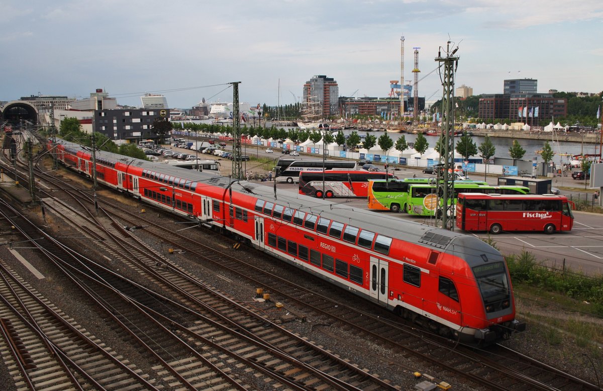 218 329-1 schiebt am Abend des 23.6.2016 den RE83 (RE21633) nach Lübeck Hauptbahnhof aus dem Kieler Hauptbahnhof. Im Hintergund läuf soeben das Fährschiff Stena Germanica nach Göteborg aus.