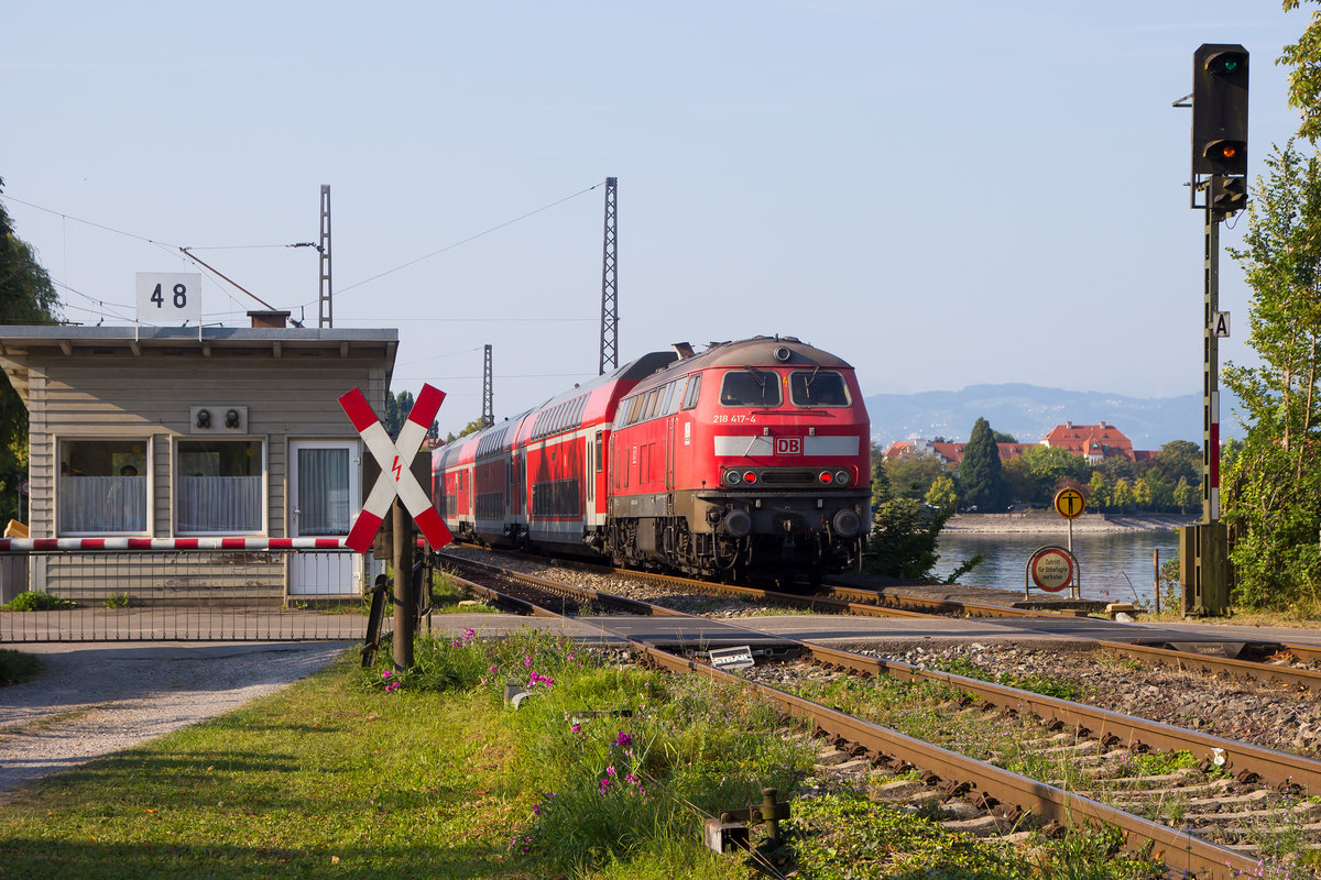 218 417-4 schiebt ihren IRE aus Friedrichshafen kommend auf den Bahndamm. 21.8.18