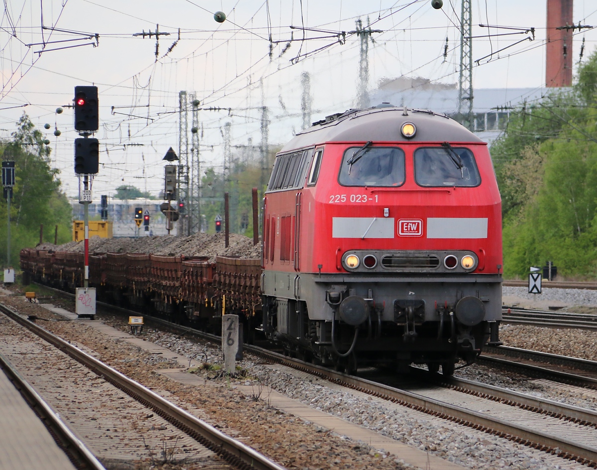 225 023-1 der EfW donnert mit Altschotter auf Flachwagen durch München-Heimeranplatz. Aufgenommen am 22.04.2014.
