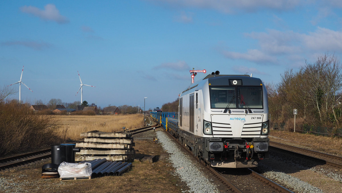 247 908  Debbie  des blauen Autozug Sylt passiert mit dem AZS 91621 Westerland -> Niebüll den Bahnhof Klanxbüll, 23.02.2018.