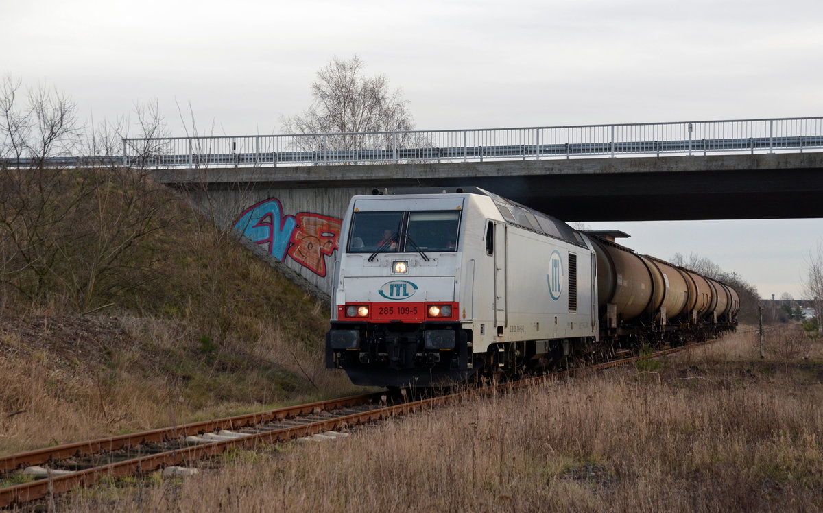 285 109 der ITL passiert mit ihrem Zug zum Zschornewitzer Empfänger Imerys Fused Minerals die Brücke der B100 in Gräfenhainichen. Der Zug kam am 01.02.18 aus Bitterfeld.