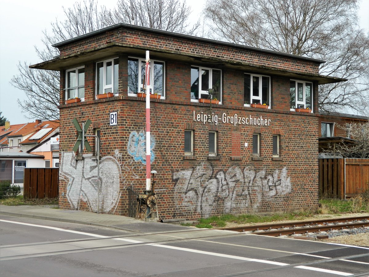 31.03.2016 - Leipzig-Großzschocher B1, Bü Gerhard Ellrodt-Straße. Hier wird die historische Schranke noch mit der Hand bedient. Im ehemaligen Stellwerk versieht der Schrankenwärter seinen Dienst.